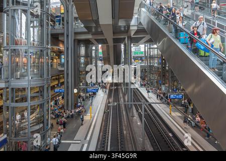 Berlino, Germania, 18 luglio 2026. Una scala mobile affollata trasporta viaggiatori con zaini e bagagli verso i binari della stazione centrale di Berlino. Gre Foto Stock