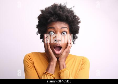 Giovane donna nera con espressione facciale scioccata Foto Stock