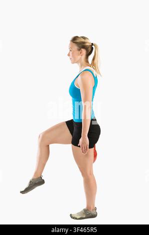 Donna atletica in equilibrio su una gamba durante il fitness funzionale Foto Stock