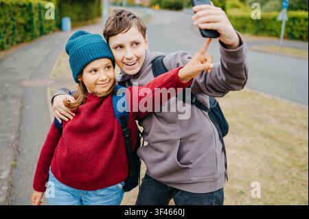 Ragazzo e ragazza che si fanno un selfie con uno smartphone all'aperto Foto Stock