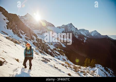 Donna felice che fa escursioni nelle montagne innevate Foto Stock