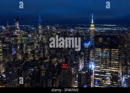 Skylines di Midtown Manhattan con l'Empire State Building di notte Foto Stock