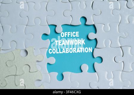 Pezzo di puzzle con la parola collaborazione lavoro di squadra in ufficio. Foto Stock