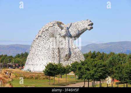 Visitatori a The Kelpies, le iconiche sculture a forma di testa di cavallo alte 30 metri a The Helix a Falkirk, in Scozia, in una limpida giornata estiva. Foto Stock