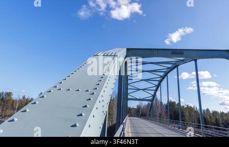 Ponte stradale in ferro ad arco costruito con travi di supporto in acciaio rivettate, Finlandia Foto Stock