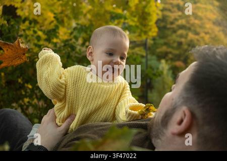 Bambino gioioso che gioca all'aperto in autunno Foto Stock