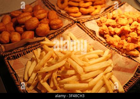 Snack fritti assortiti in cestini come patatine fritte croccanti, anelli di cipolla, pezzetti di pollo e impasto serviti in un ristorante a Changsha City, Hunan Foto Stock