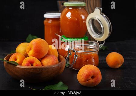 Marmellata di albicocche fatta in casa in barattoli di vetro con albicocche fresche Foto Stock