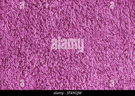 Primo piano, macro texture di asciugamano da bagno in microfibra rosa, superficie morbida e soffice in spugna, dettagli di tessuto assorbente. Sfondo in materiale tessile accogliente per ba Foto Stock