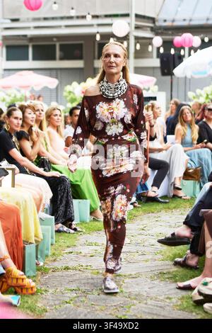Monaco di Baviera, Germania, 16 luglio 2026. Modella sfilata nella mostra Marcel Ostertag SS27 per il 20° anniversario al Parkhotel Rothof in un abito lungo marrone con stampa floreale. Foto Stock