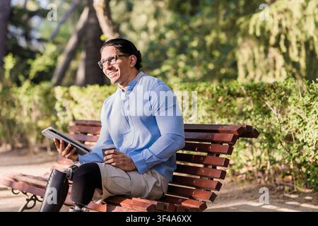 Lavoratore latino con gamba protesica che si gode una pausa nel parco Foto Stock