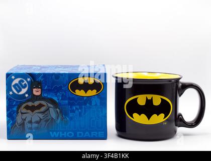 Tazza da caffè in ceramica nera a tema Batman e confezione grafica blu originale, isolata su sfondo bianco. Foto Stock
