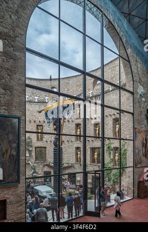 Vista attraverso una grande finestra del cortile del Teatro-Museo Dalí a Figueres, in Spagna, con sculture surrealiste e manichini dorati. Foto Stock