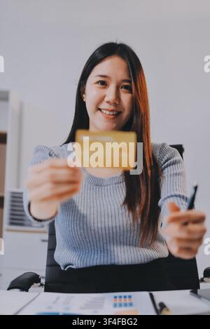 Giovane donna imprenditrice asiatica che utilizza smartphone e carta di credito per gli acquisti online. Pagamento online. Foto Stock