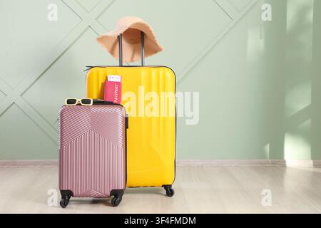 Due valigie colorate con passaporto, biglietti d'imbarco, occhiali da sole e un cappello di paglia, pronte per il viaggio e le vacanze Foto Stock