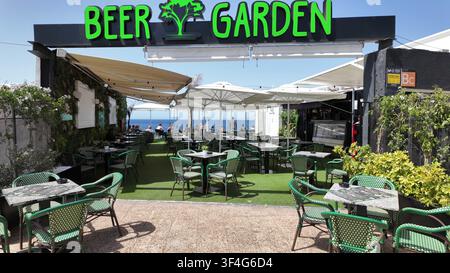 PUERTO DEL CARMEN, SPAGNA - 10 LUGLIO 2025: Area di seduta all'aperto vuota su una terrazza di birreria con vista sull'oceano a Puerto del Carmen, Lanzarote, Sp Foto Stock