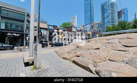 TORONTO, CANADA - 15 LUGLIO 2024: Il monumentale punto di riferimento in granito al Village of Yorkville Park circondato da edifici moderni a Toronto, Canada. Foto Stock