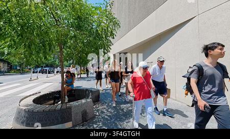 TORONTO, CANADA - 15 LUGLIO 2024: Diversi pedoni camminano lungo il marciapiede di cemento davanti a negozi di lusso su Bloor Street nel centro di Toronto, Canada. Foto Stock
