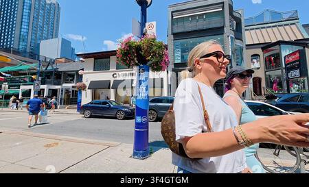TORONTO, CANADA - 15 LUGLIO 2024: Pedoni passano davanti a negozi boutique su Bloor Street nel quartiere Yorkville di Toronto, Canada. Foto Stock