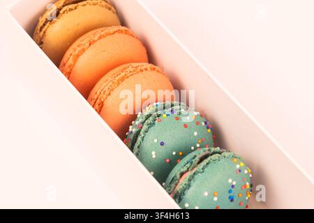 Primo piano di macaron colorati in una scatola regalo Foto Stock