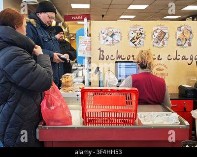 Kirov, Russia – 8 febbraio 2026: I clienti fanno la fila alla cassa di un supermercato mentre gli addetti alla cassa li assistono con i loro acquisti. Foto Stock