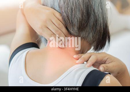 Vista posteriore di una donna matura che soffre di dolori al collo e alle spalle. Concetto di assistenza sanitaria e medica. Foto Stock