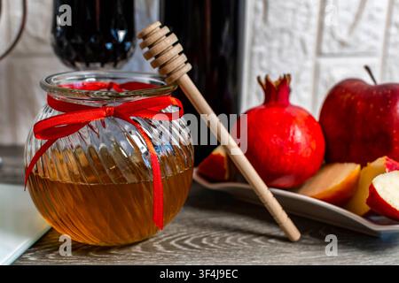 Miele in un barattolo con mele e melograno per la celebrazione di Rosh Hashanah Foto Stock