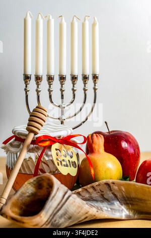 Simboli delle festività di Rosh Hashanah tra cui miele, uno shofar, mela, melograno e una menorah Foto Stock