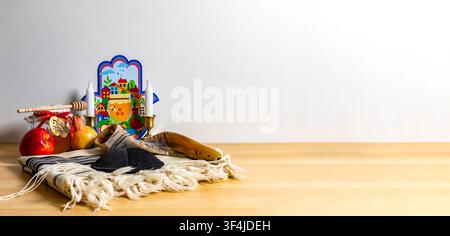 Simboli ebraici per il nuovo anno tra cui shofar, miele, mela e hamsa su un tavolo di legno Foto Stock
