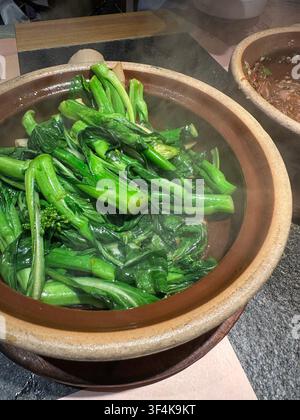 Broccolo cinese stir-fry (Gai Lan) con aglio servito in una pentola di terracotta in un ristorante, Foshan City, provincia di Guangdong in Cina Foto Stock