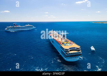 Le Isole Berry, Bahamas – 02 maggio 2020: Veduta aerea di due navi da crociera Carnival che navigano nelle acque blu profonde del Mar dei Caraibi sotto un cl Foto Stock