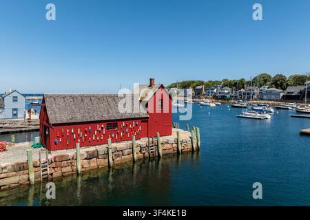 Vista aerea del Motivo Numero 1, l'iconica capanna da pescatore rossa, circondata da barche nel porto sotto un cielo blu terso a Rockport, Massachusetts, Uni Foto Stock