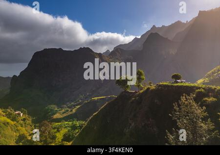 Vista aerea della Trilha do Vale do Paul che si snoda attraverso montagne verdi lussureggianti con luce drammatica e ombre a Faja de Cima, Paul, Capo Verde. Foto Stock