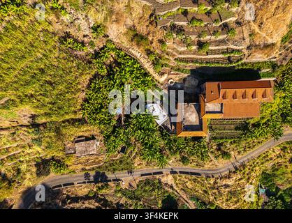 Veduta aerea della Trilha do Vale do Paul, che mostra campi terrazzati, piantagioni di banane, una casa con tetto di tegole e una strada tortuosa, Faja de Cima, Paul Foto Stock