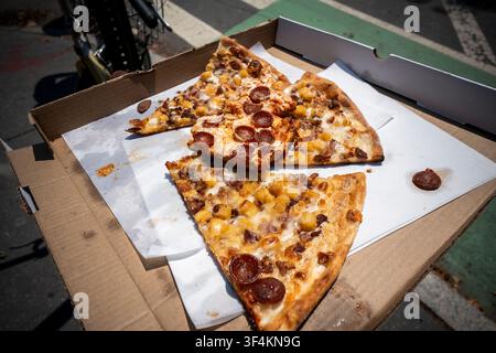 Fette di pizza abbandonata e mangiata a metà sono lasciate per strada a Greenwich Village a New York sabato 11 luglio 2026. (© Richard B. Levine) Foto Stock