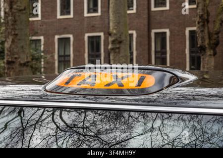 Luce sul tetto del taxi su un veicolo nero parcheggiato in città Foto Stock