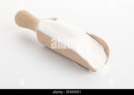 Bicarbonato di sodio in un cucchiaio di legno su sfondo bianco Foto Stock
