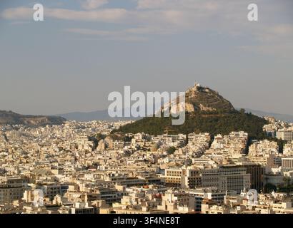 Vista panoramica della città di Atene con il monte Licabetto che si staglia all'orizzonte sotto un cielo azzurro limpido in Grecia Foto Stock