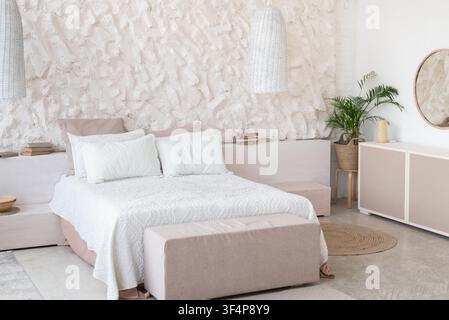 Camera da letto minimalista moderna con letto accogliente e piante decorative, concetto di interior design Foto Stock