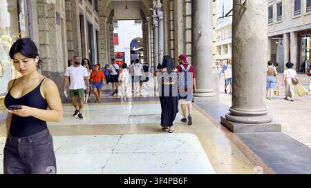 MILANO, ITALIA - 15 LUGLIO 2024: Pedoni camminano lungo le arcate in pietra coperte del Corso Vittorio Emanuele II vicino al centro città di Milano, Italia. Foto Stock