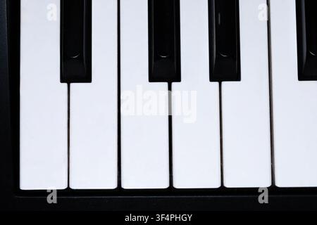 Prima vista delle tastiere bianche e nere di un pianoforte che mostrano un classico schema di tastiera musicale. Ideale per concetti di musica, educazione e strumenti. Foto Stock