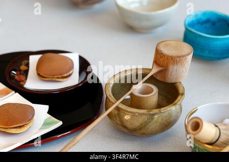 I dorayaki giapponesi tradizionali vengono serviti su vassoi insieme a utensili per la cerimonia del tè in bambù. Foto Stock