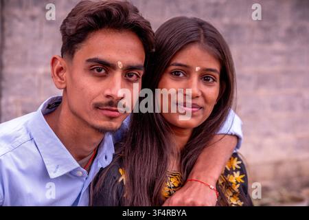 Una giovane coppia indiana indossa una tika sulla fronte. L'uomo indossa una camicia blu e la donna un vestito ricamato. Sono i Foto Stock