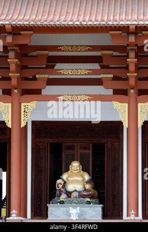 Pagoda di Quoc An Khai Tuong. Statua dorata di Maitreya Buddha. La sua espressione gioiosa, la pancia rotonda e gli accessori simboleggiano la prosperità e lo spirituale c Foto Stock