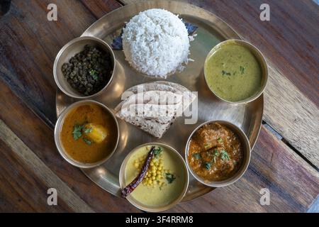 Un thali indiano completo servito in ciotole di metallo su un vassoio, inclusi riso, chapati, vari curry e verdure, a Palampur, Himachal Pradesh, India Foto Stock
