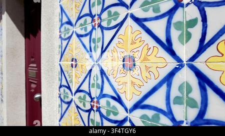 Prima vista angolata di piastrelle in ceramica smaltate azulejo colorate con motivi geometrici e floreali ornati sotto una luce naturale brillante, che evidenzia Foto Stock