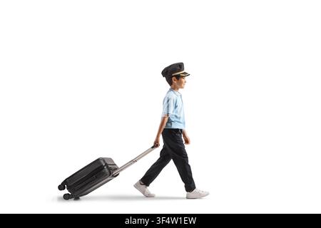 Bambino vestito da pilota che cammina e tira una valigia isolato su sfondo bianco Foto Stock