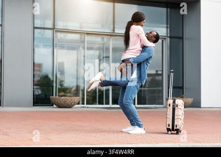 Reunion attesa da tempo. Happy excited African American Couple Meeting Near Airport Exit Foto Stock