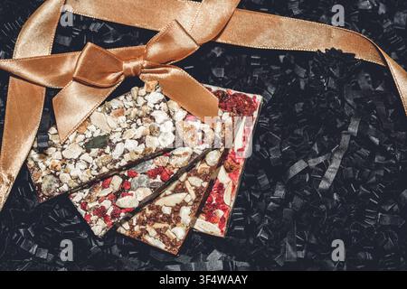 Una selezione di deliziose barrette di cioccolato artigianale fatte a mano con ingredienti come noci, bacche secche e semi Foto Stock