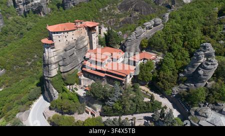 Vista aerea dell'antico monastero di Rousanou circondato da una lussureggiante foresta verde a Meteora, Grecia Foto Stock